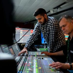 Mastering engineer finalizing a stereo master on a large studio console with DAW screen in the background. Logic Pro Mastering Course hero image.