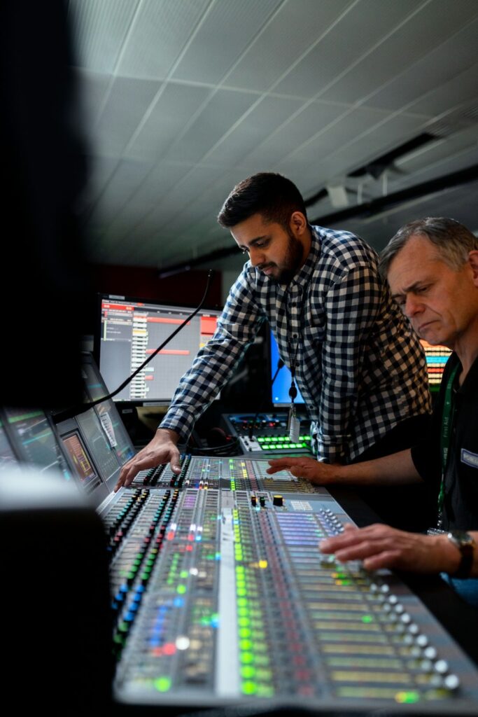 Mastering engineer finalizing a stereo master on a large studio console with DAW screen in the background. Logic Pro Mastering Course hero image.